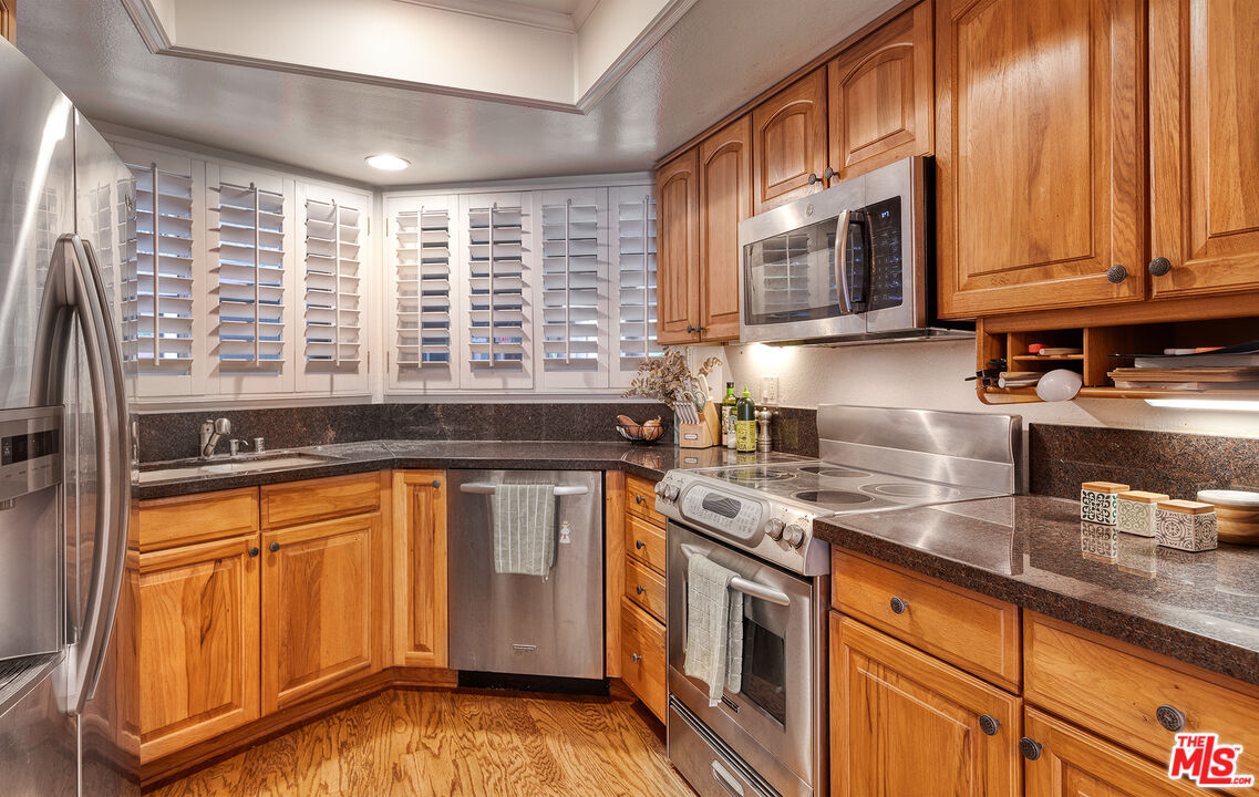 4350 Vía Dolce, Unit 105 Marina del Rey, CA 90292 - Photo 13 of 31 a kitchen with stainless steel appliances granite countertop a stove a sink and a microwave