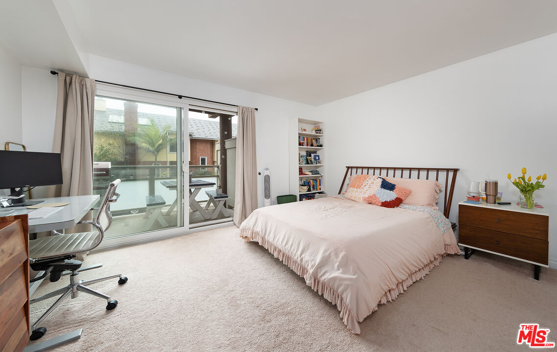 4350 Vía Dolce, Unit 105 Marina del Rey, CA 90292 - Photo 16 of 31 a large bed sitting in a bedroom next to a large window with chair and table