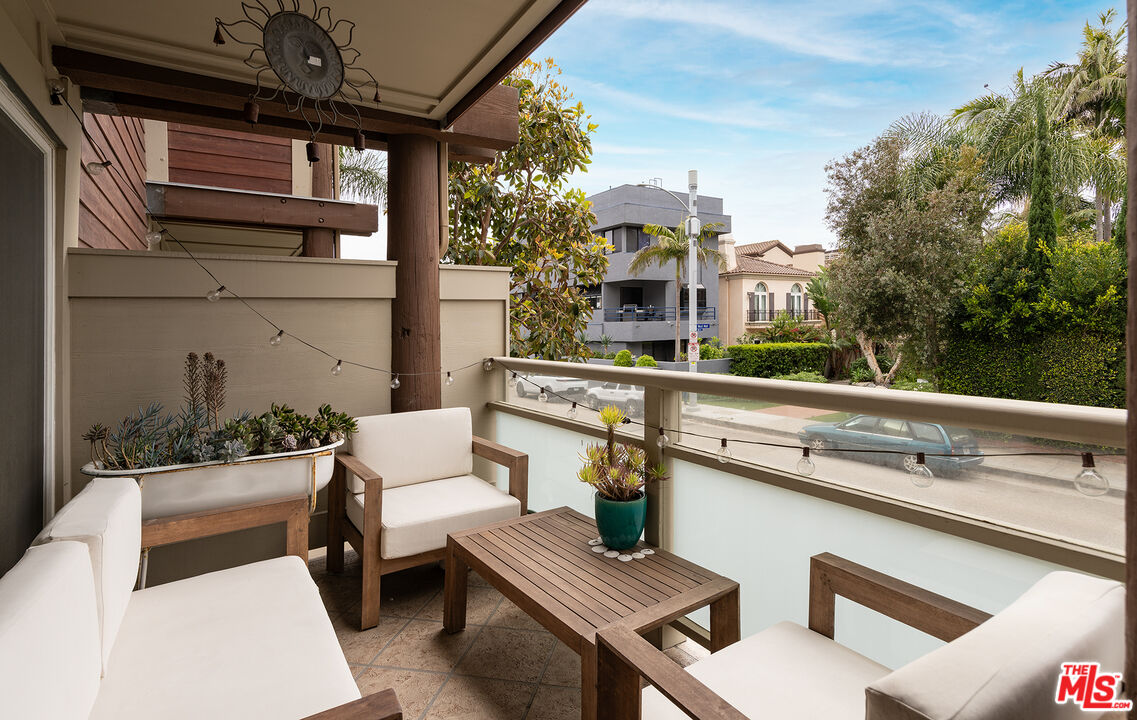 4350 Vía Dolce, Unit 105 Marina del Rey, CA 90292 - Photo 5 of 31 a view of a patio with couches table and chairs with wooden floor and fence