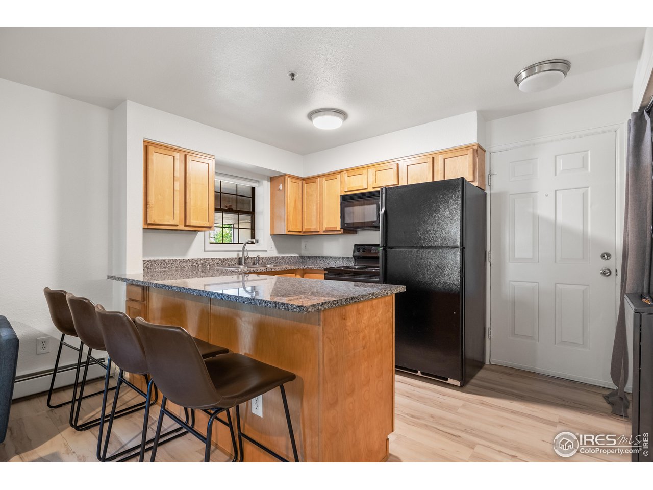 1405 Broadway, Unit 101 Boulder, CO 80302 - Photo 3 of 22 a kitchen with refrigerator and chairs