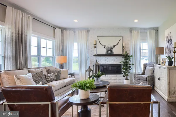 a living room with furniture a fireplace and a large window