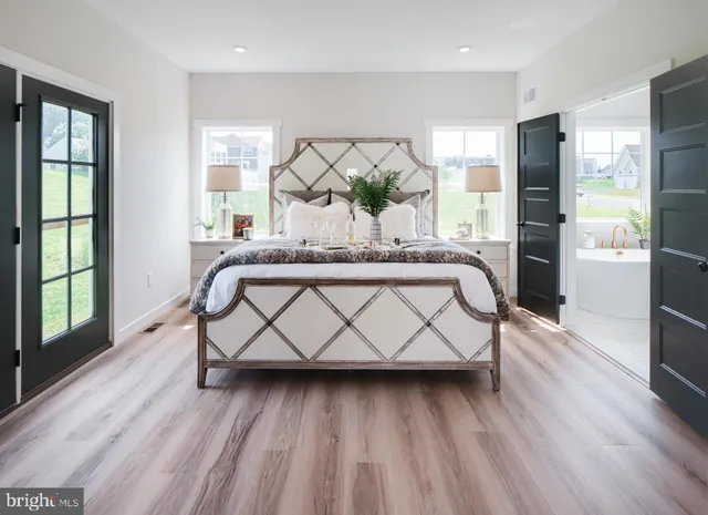 a bedroom with a bed and wooden floor