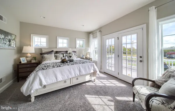 a spacious bedroom with a bed and glass window