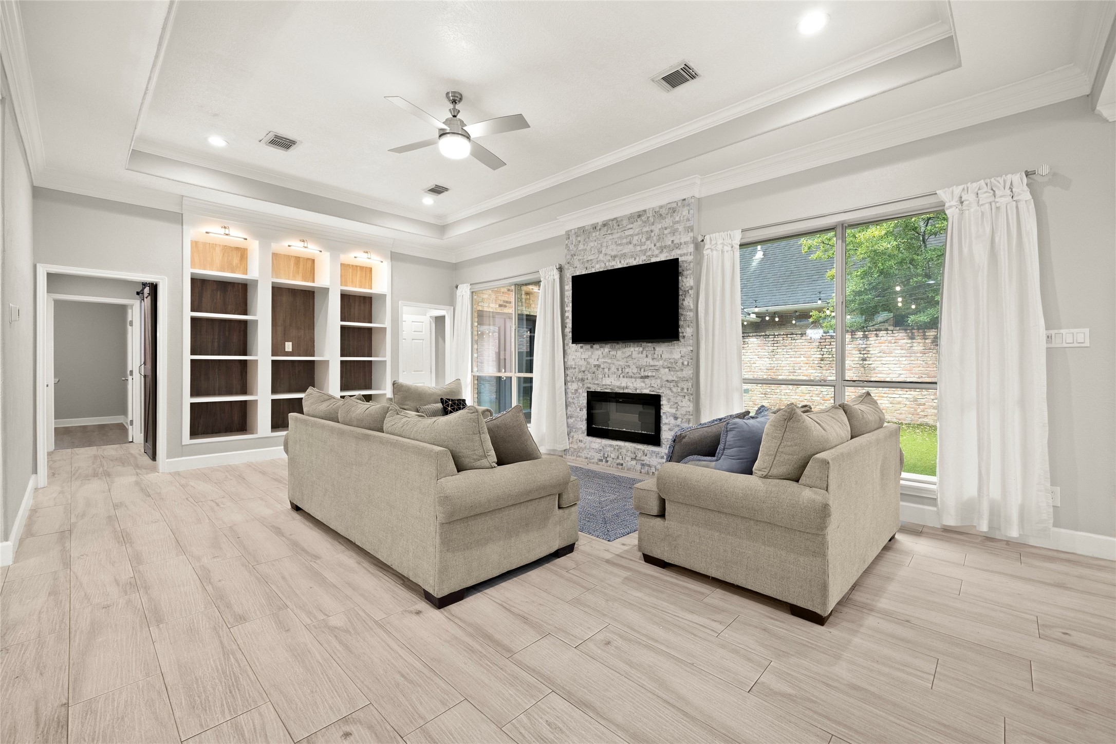 6239 Agassi Ace Court Spring, TX 77379 - Photo 3 of 19 Stunning living space with an entire wall of built-in shelving with lighting