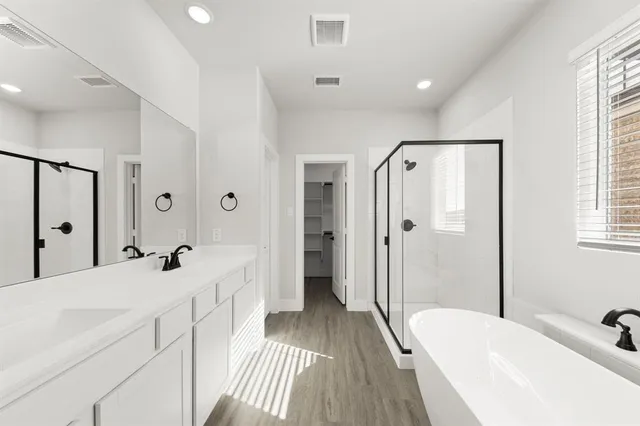 a spacious bathroom with sink shower and a bathtub