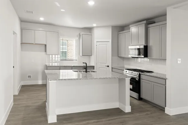 a kitchen with stainless steel appliances granite countertop a sink stove and refrigerator