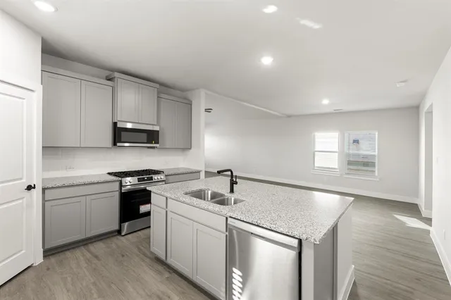 a kitchen that has a sink a stove and cabinets