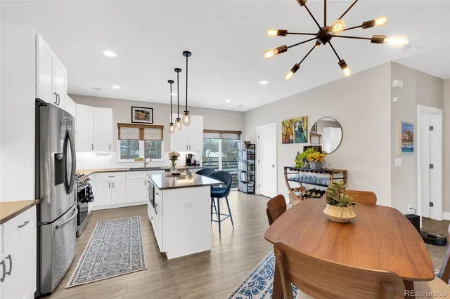 a kitchen with a table chairs refrigerator and microwave