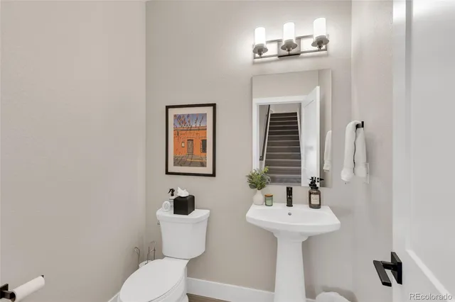 a bathroom with a sink mirror and toilet