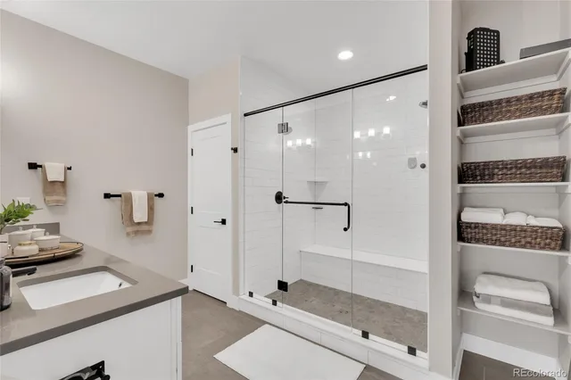 a bathroom with a granite countertop sink mirror and shower