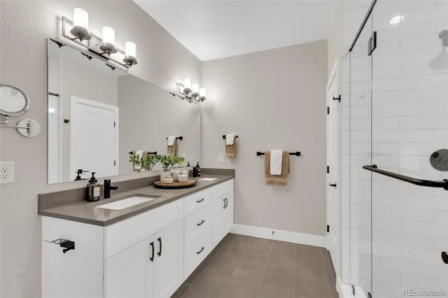 a bathroom with a double vanity sink mirror and shower