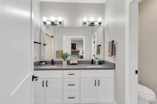 a bathroom with double vanity and a mirror