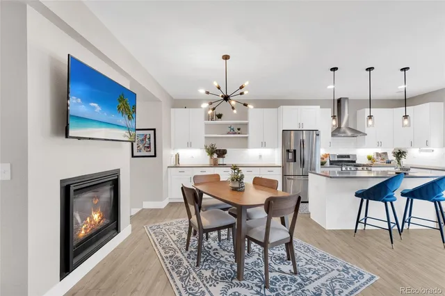 a dining room with furniture a fireplace and wooden floor