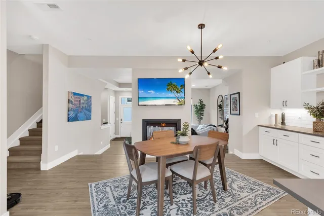 a dining room with furniture a fireplace and a chandelier