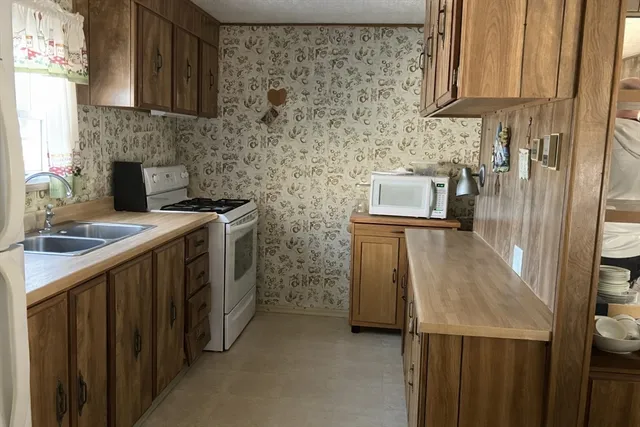 a kitchen with stainless steel appliances a stove a sink and a refrigerator