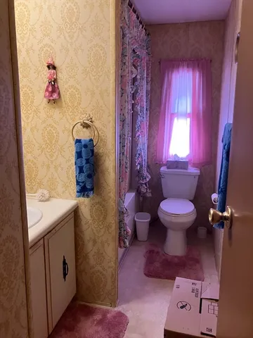 a bathroom with a granite countertop toilet sink and mirror