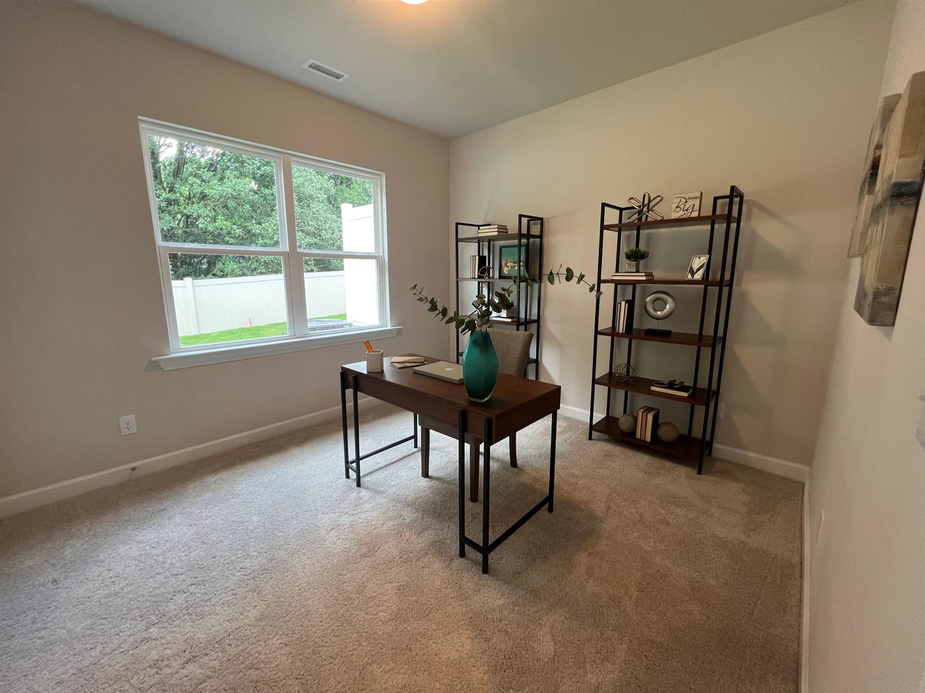 7908 Sofiana Avenue Raleigh, NC 27617 - Photo 12 of 26 a living room with furniture a window and a bookshelf