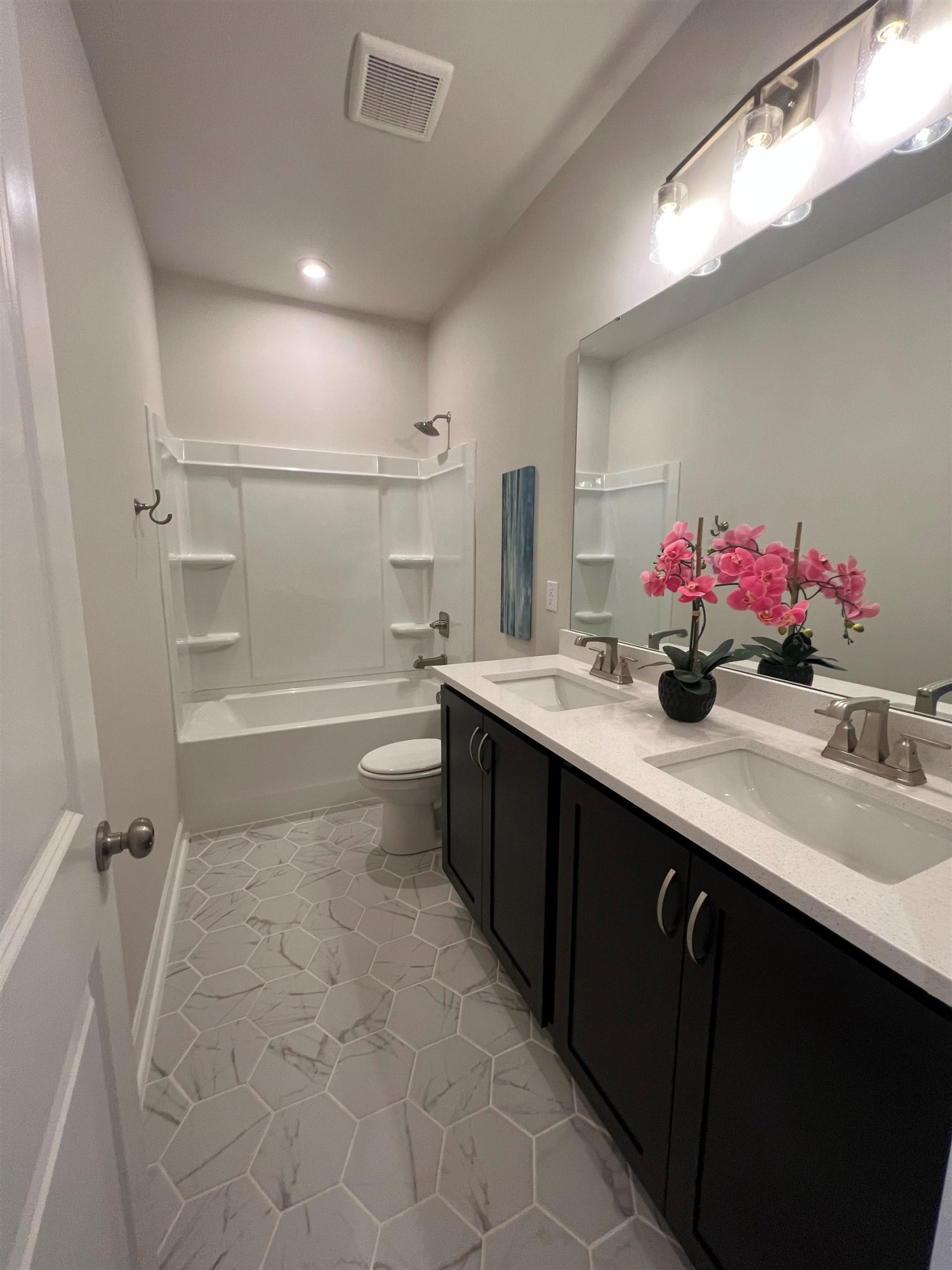 7908 Sofiana Avenue Raleigh, NC 27617 - Photo 17 of 26 a bathroom with a double vanity sink a mirror and shower