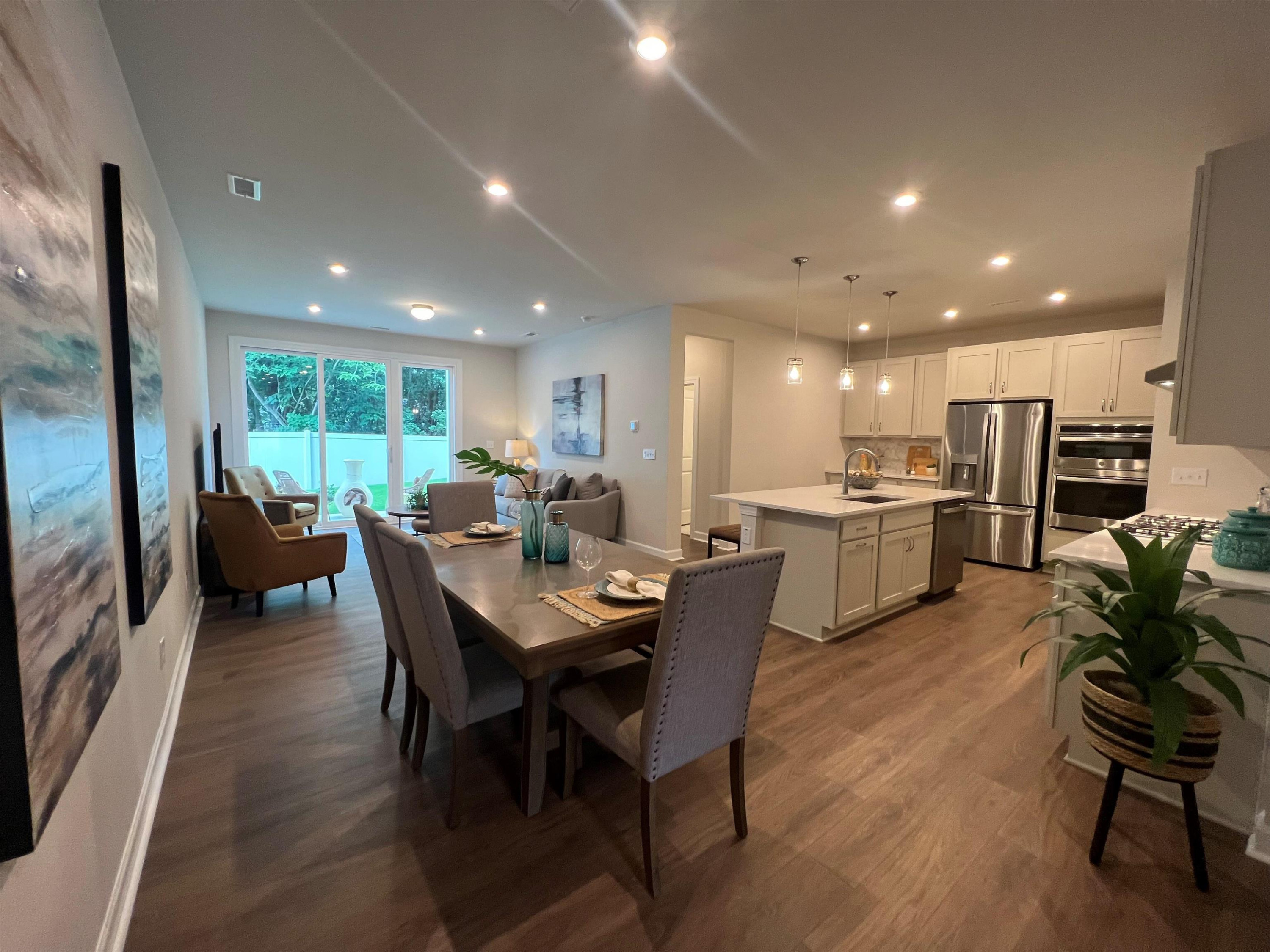 7908 Sofiana Avenue Raleigh, NC 27617 - Photo 5 of 26 a view of a dining room with furniture a kitchen and chandelier