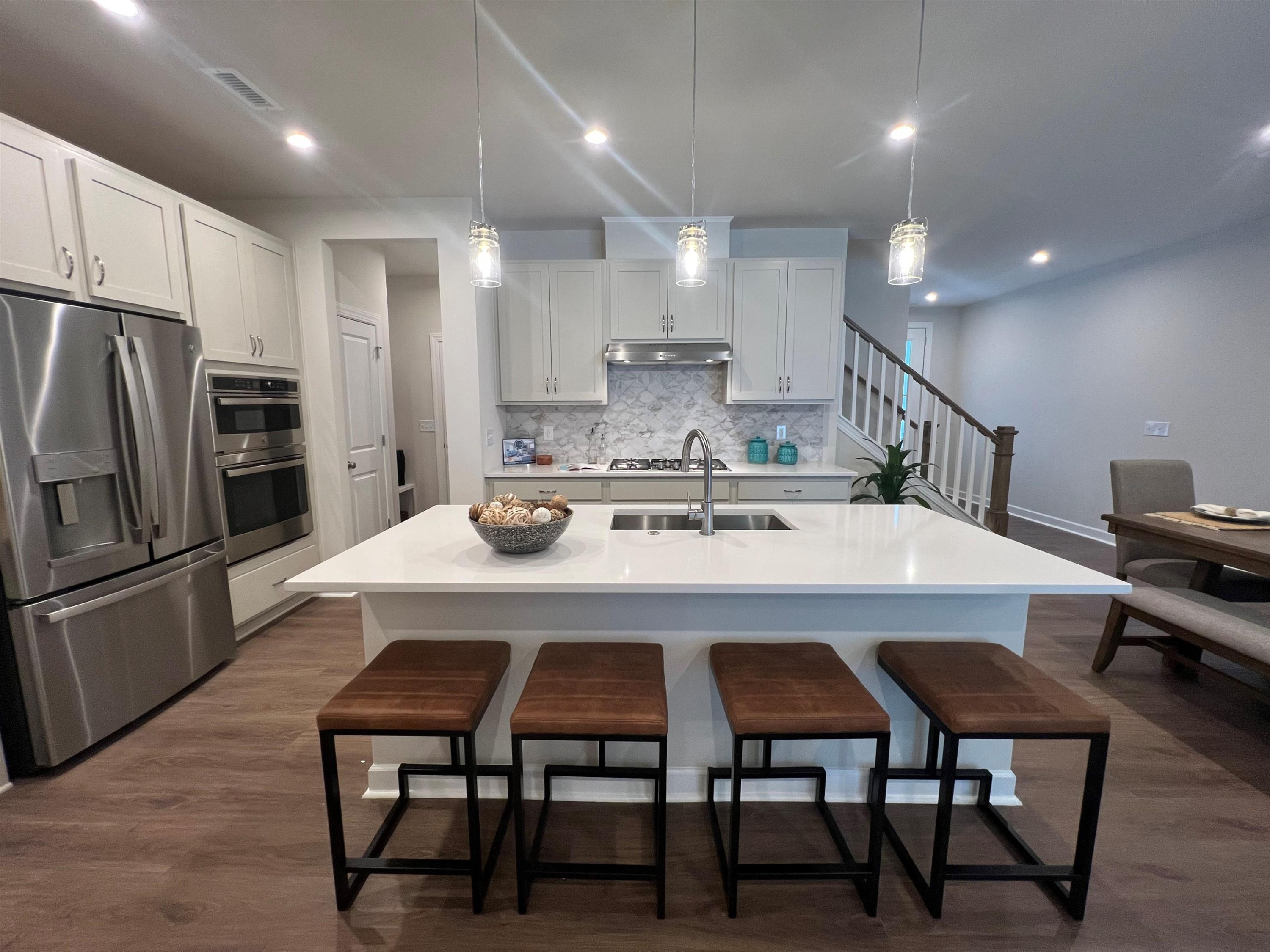 7908 Sofiana Avenue Raleigh, NC 27617 - Photo 10 of 26 a kitchen with stainless steel appliances a dining table chairs refrigerator and microwave