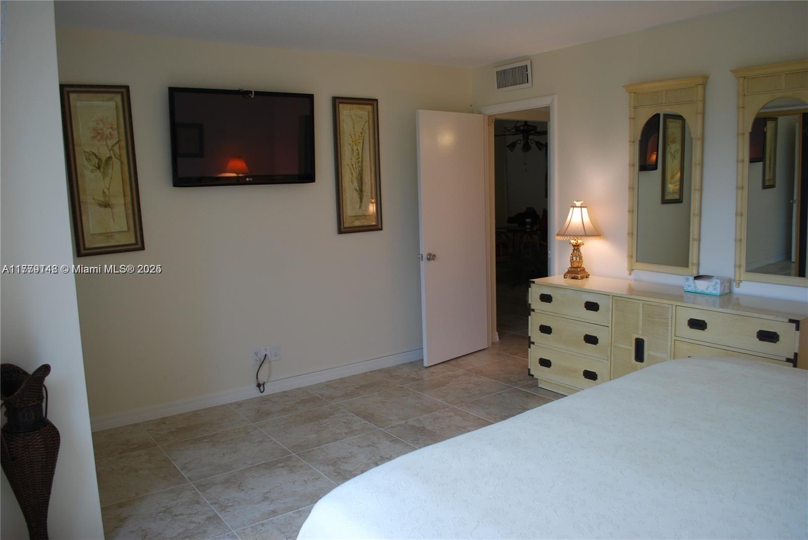 125 South Ocean Avenue, Unit 214 Palm Beach Shores, FL 33404 - Photo 15 of 26 a bedroom with a bed and furniture