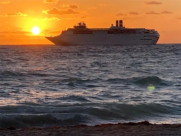 a living room with furniture a flat screen tv and paintings on the wall