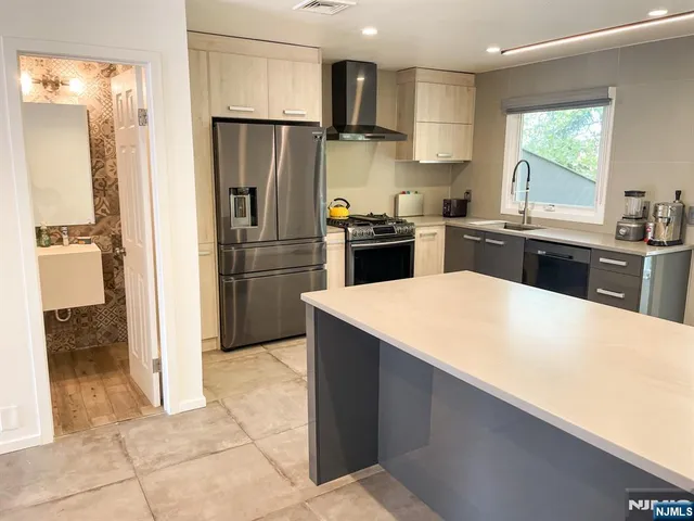 a kitchen with stainless steel appliances a refrigerator sink and cabinets