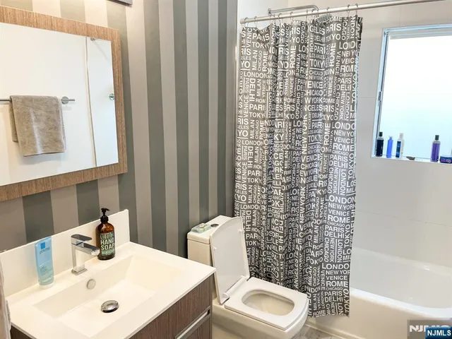 a bathroom with a sink a toilet and shower curtain