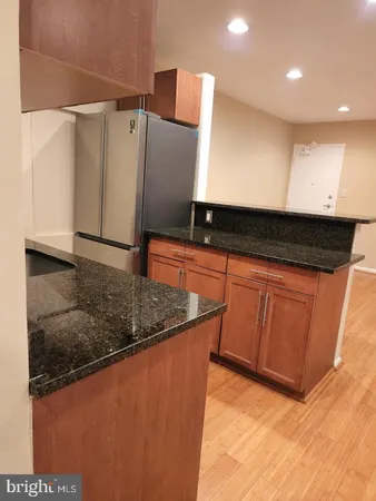 a kitchen with stainless steel appliances granite countertop a sink and a refrigerator