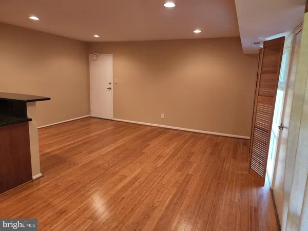 an empty room with wooden floor and entrance