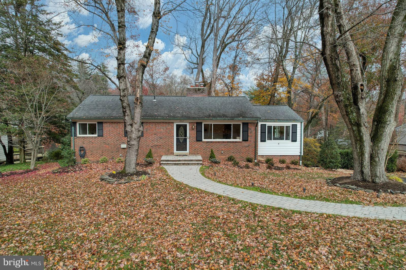 1912 Pagebrook Road Silver Spring, MD 20903 - Photo 50 of 52 a front view of a house with a dirt yard and large tree