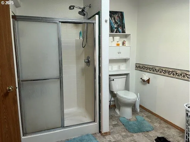 a bathroom with a toilet and a shower