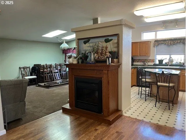 a living room with furniture a fireplace and a dining table with wooden floor