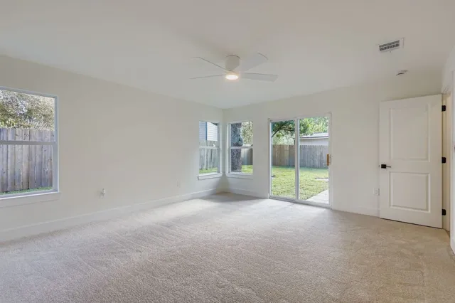 a view of an empty room with a fireplace and a window