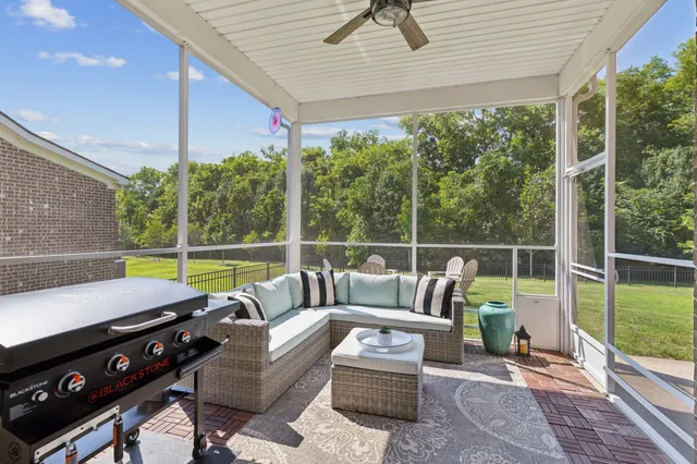 a view of a patio with couches chairs and wooden floor