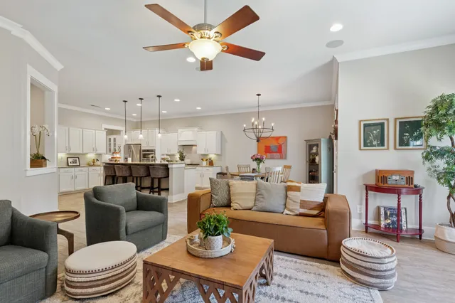 a living room with furniture kitchen view and a chandelier