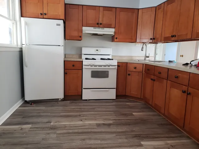 a kitchen with a white stove top oven and refrigerator