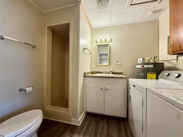 a bathroom with a granite countertop sink toilet and shower