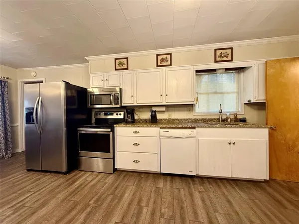 a kitchen with stainless steel appliances granite countertop a refrigerator and a stove
