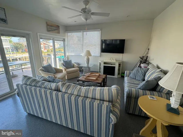 a living room with furniture a flat screen tv and a large window