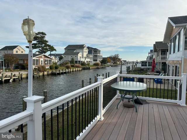 a view of a lake from a balcony with chairs