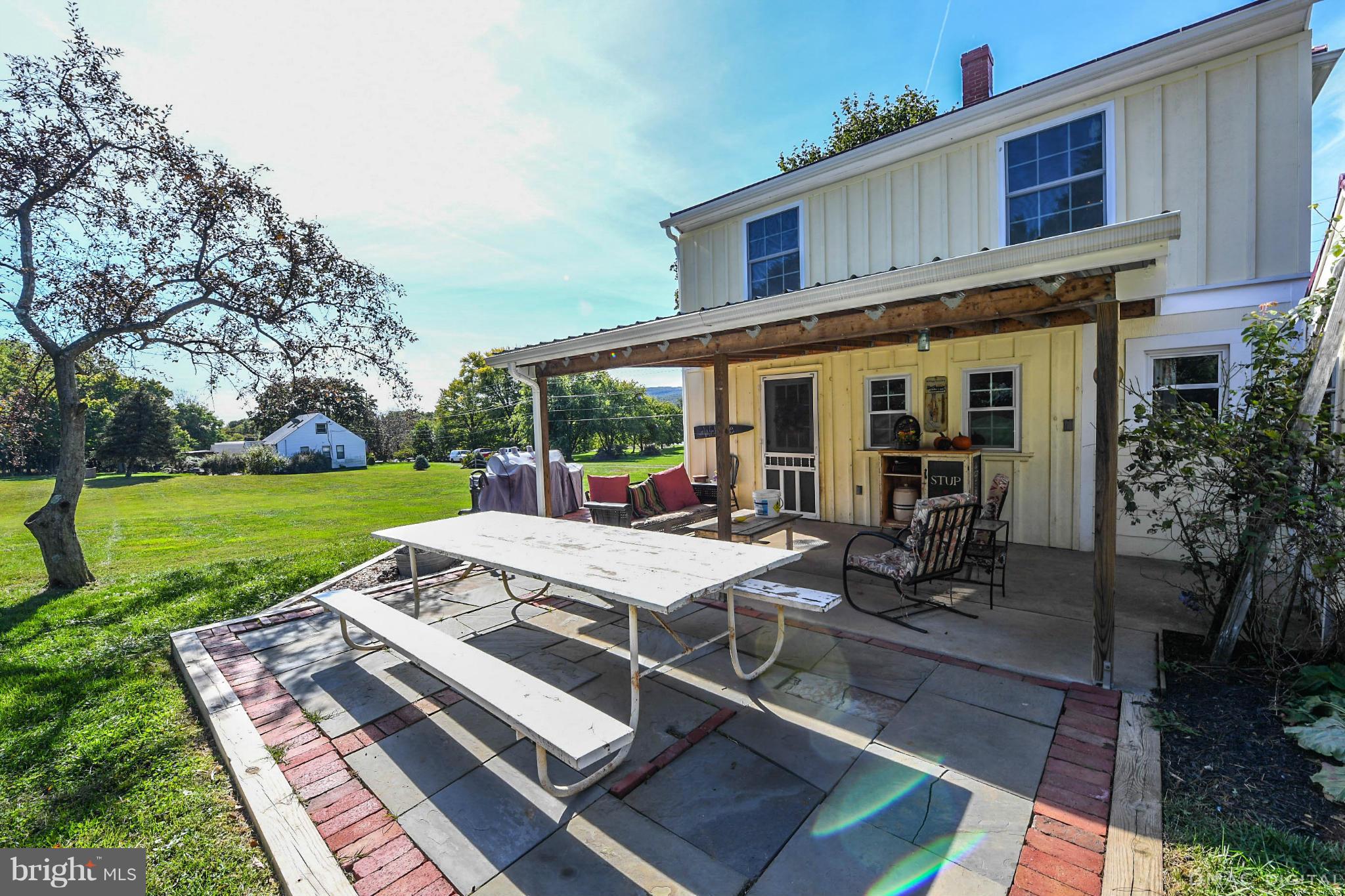8701 Yellow Springs Road, Unit C Frederick, MD 21702 - Photo 22 of 30 a view of a patio with table and chairs potted plants and large tree