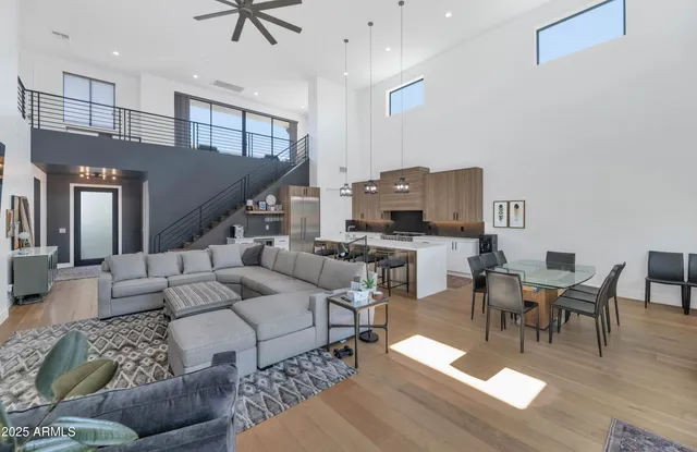 a living room with furniture kitchen view and a wooden floor