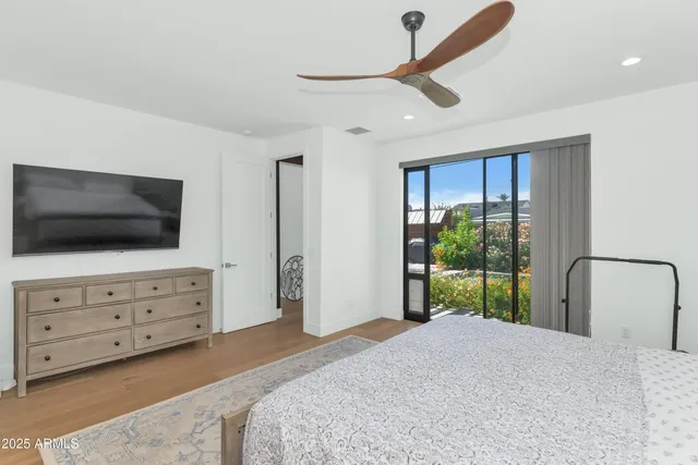 a bedroom with a bed flat screen tv and a window