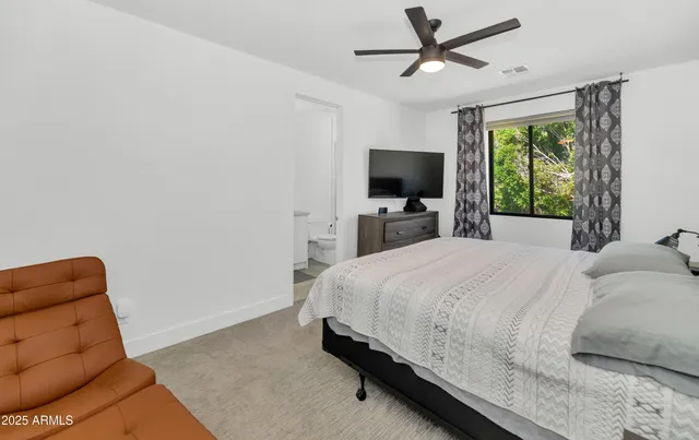 a bedroom with a bed a window and a television