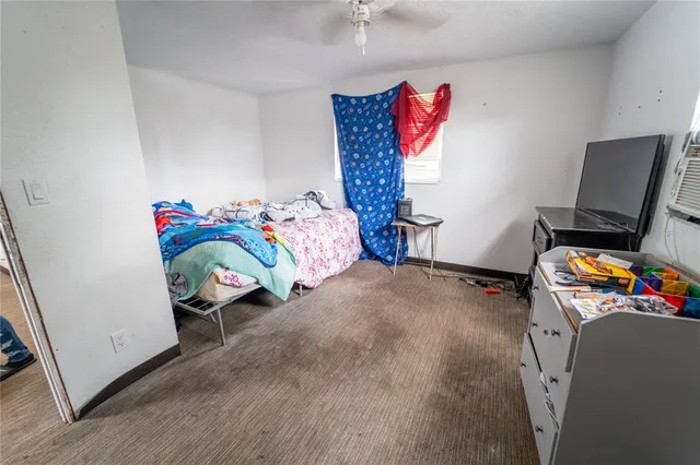 a view of a bedroom with baby crib and cabinet