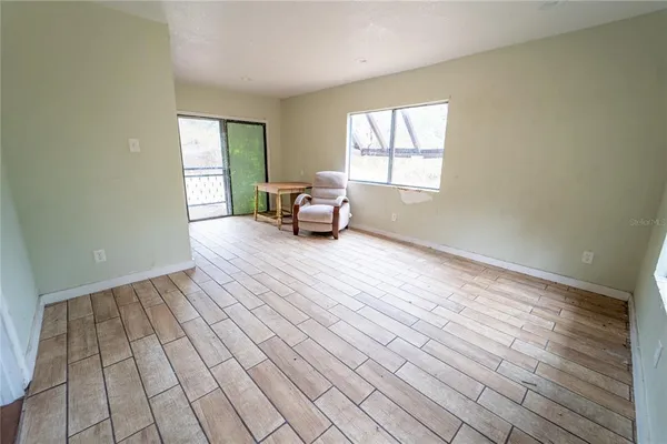 a view of a room that has a window and wooden floor
