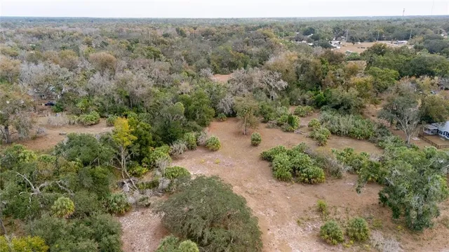 an aerial view of lake and residential houses with outdoor space and trees
