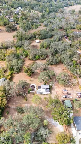 an aerial view of house with yard and mountain view in back