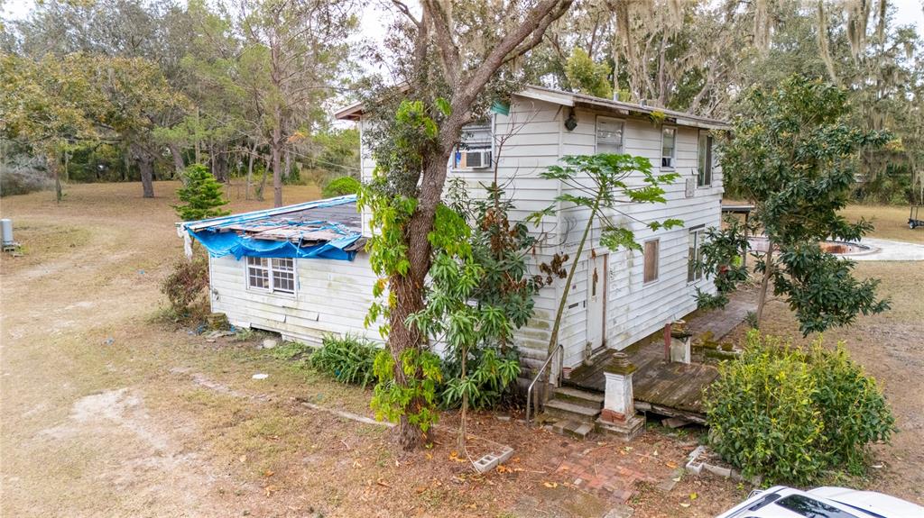 7813 Valrie Lane Riverview, FL 33569 - Photo 7 of 48 a pathway of a house with potted plants and a bench